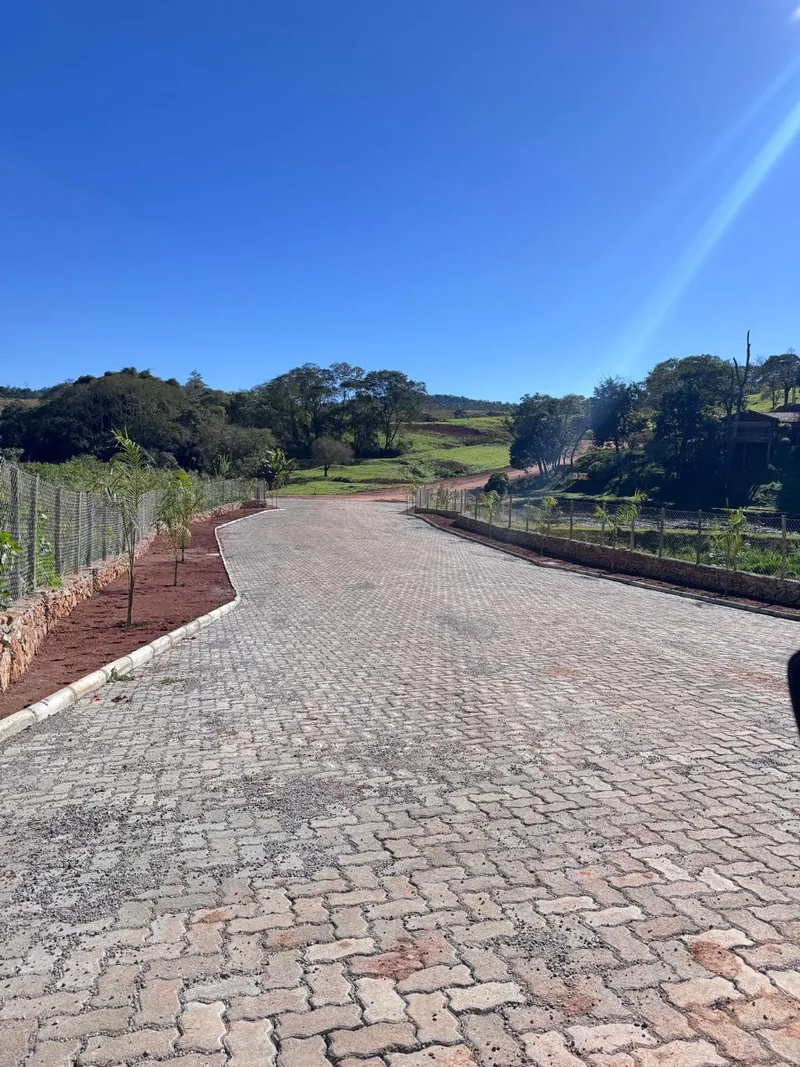 Trecho de via pavimentada no Mariah, com guia, sarjeta e paisagem arborizada