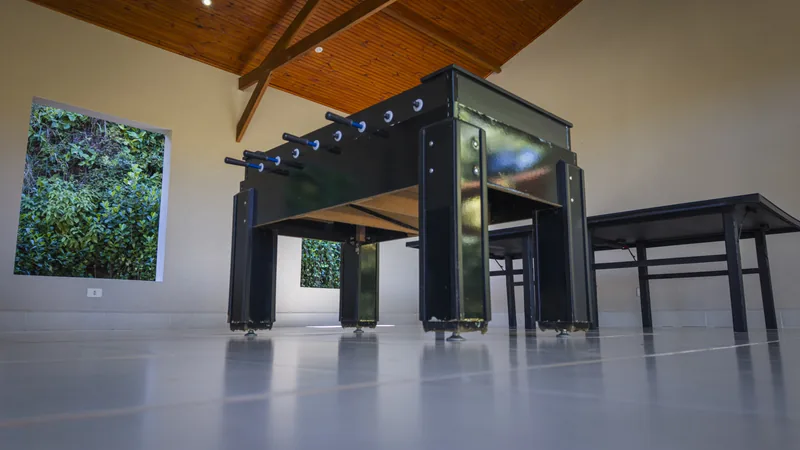 Salão de jogos com mesa de pebolim e tênis de mesa