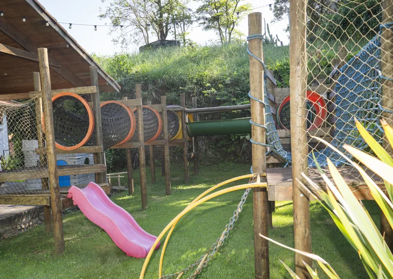 Playground com escorregadores, balanços e brinquedos de madeira